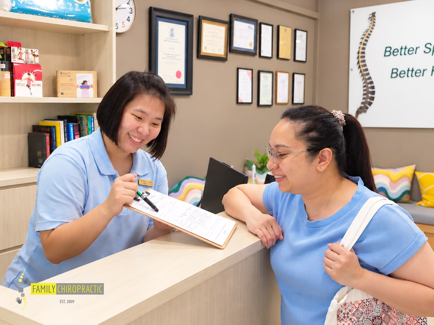 Family Chiropractic clinic team member going through a form with a patient at reception