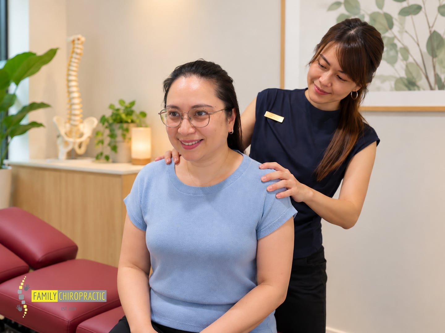 Chiropractor at Family Chiropractic in Singapore speaking with a smiling patient during her first visit