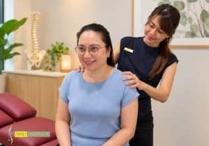 Chiropractor at Family Chiropractic in Singapore speaking with a smiling patient during her first visit