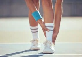 Tennis athlete with ankle injury, pain and hurt on a court after training, workout or practice outd.