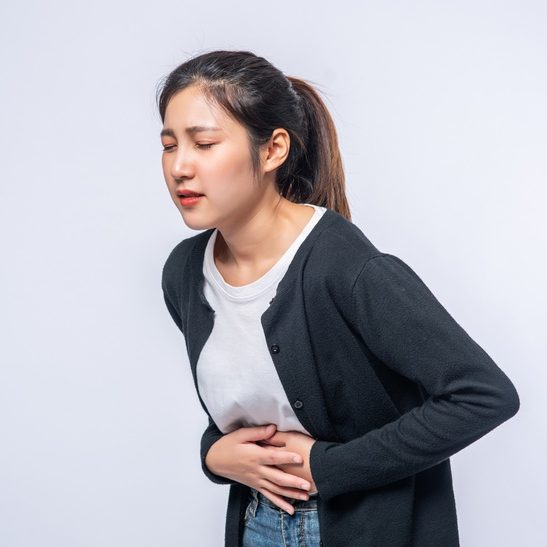 woman-standing-with-stomach-ache-presses-her-hand-her-stomach_1150-25976